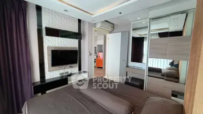 Modern bedroom with stylish decor and wall-mounted TV in a cozy apartment.
