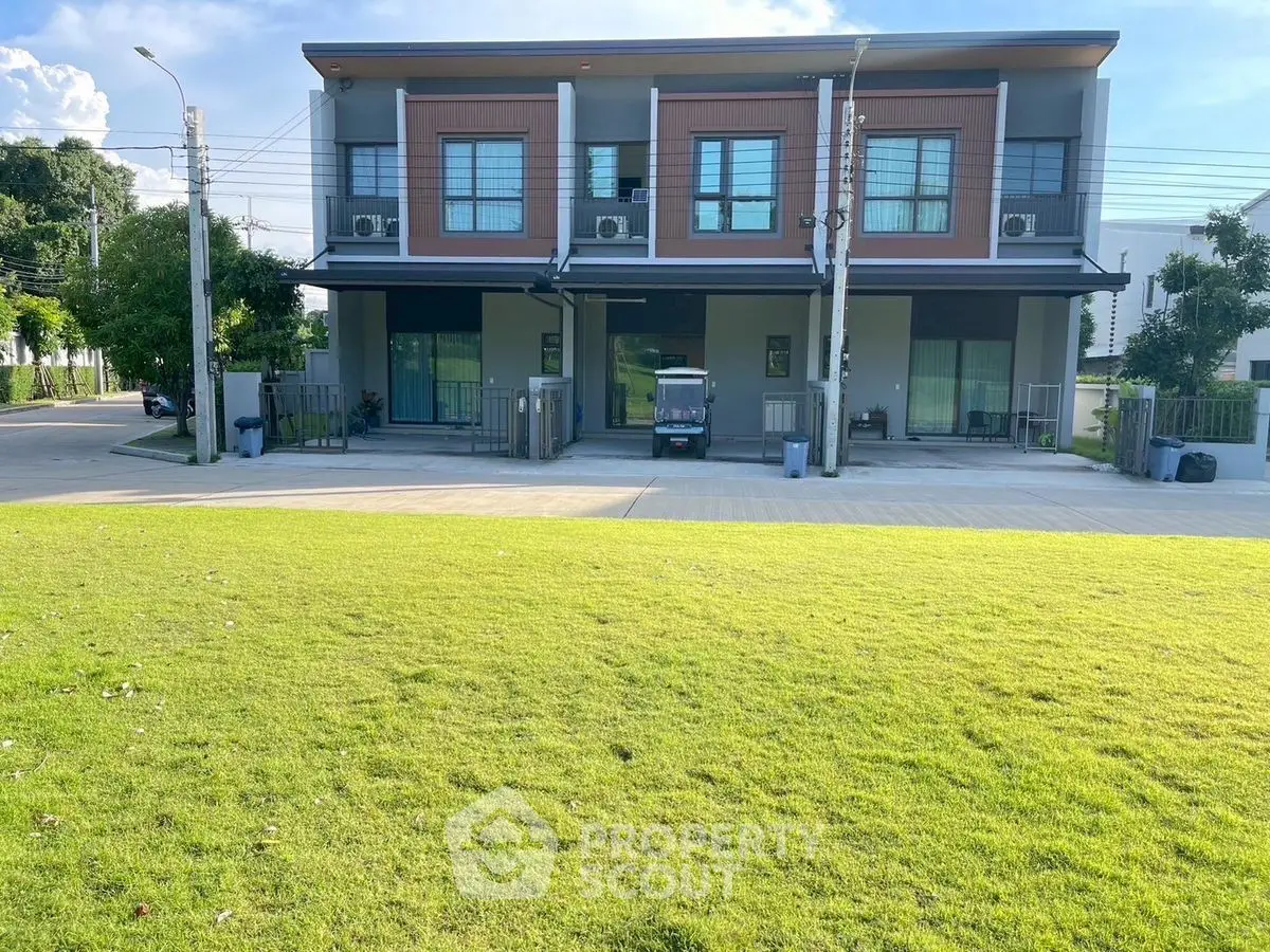 Modern two-story building with lush green lawn and large windows