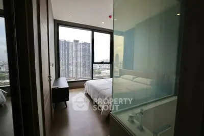 Modern bedroom with city view and glass partition in high-rise apartment