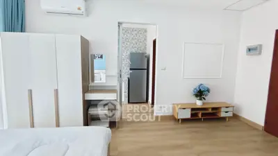 Modern bedroom with stylish furniture and open layout, featuring a sleek wardrobe and cozy decor.