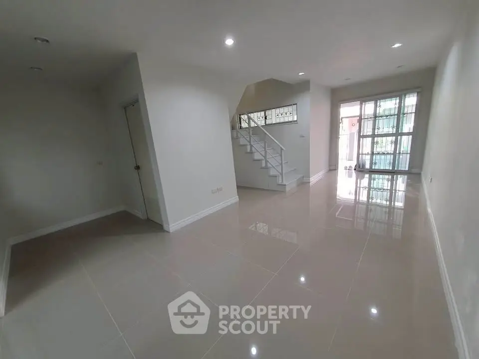 Spacious modern living room with glossy tiled floors and natural light