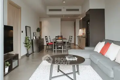 Modern open-plan living room with stylish furniture and dining area in a contemporary apartment.