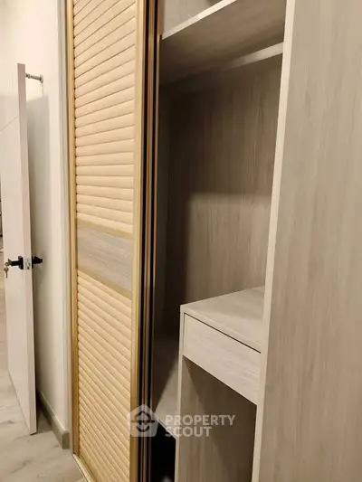 Spacious built-in wooden wardrobe with sliding doors in modern interior design.