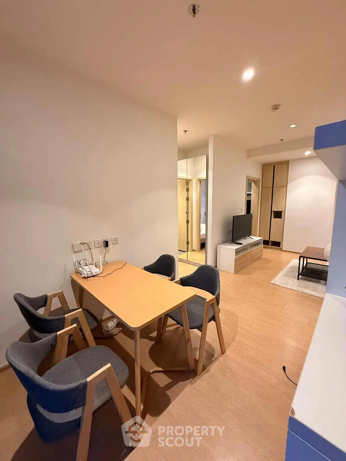 Modern living room with dining area and TV setup in stylish apartment