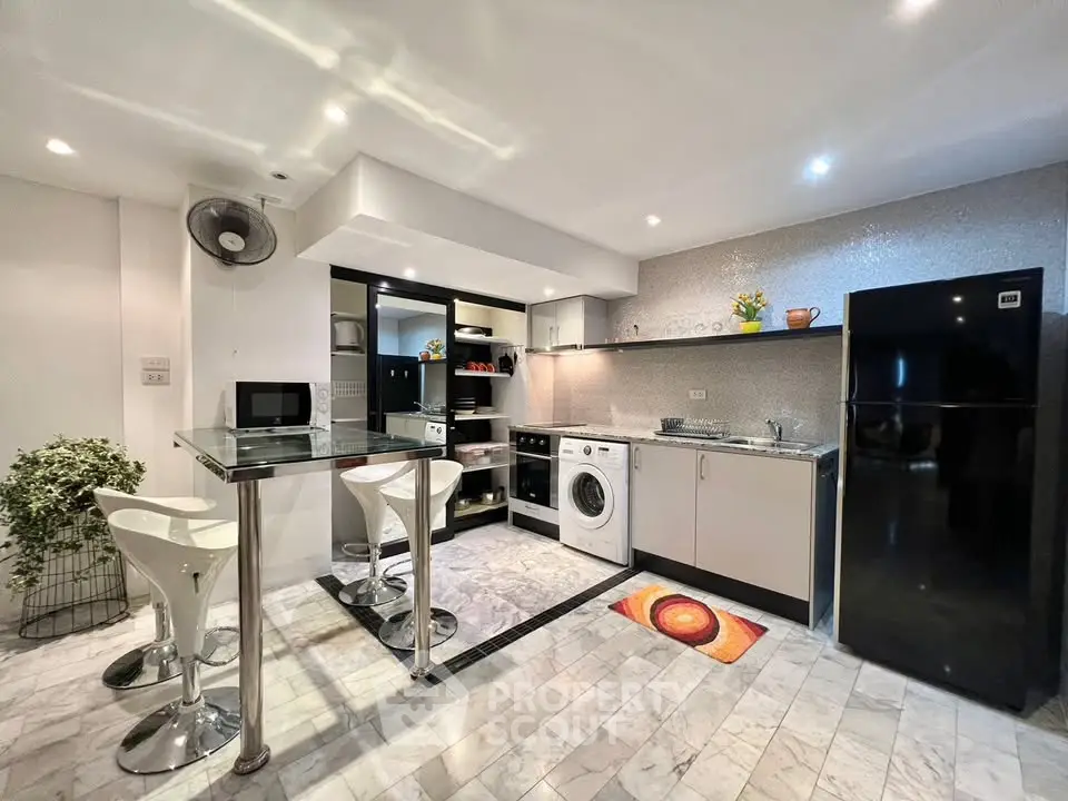 Modern kitchen with sleek appliances and stylish breakfast bar in a contemporary apartment.
