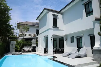 Luxurious modern villa with private pool and elegant outdoor seating area.