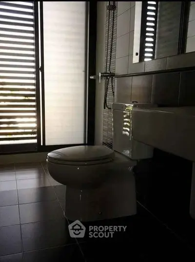 Modern bathroom with sleek design and large window for natural light.