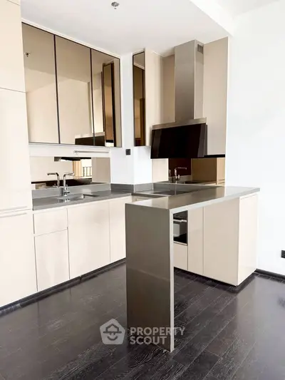 Modern kitchen with sleek cabinetry and dark flooring, featuring a minimalist design.