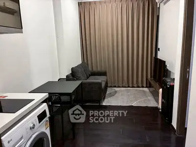 Modern living room with dark wood flooring, cozy sofa, and compact dining area in a stylish apartment.