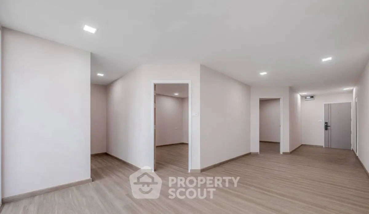 Spacious modern apartment interior with sleek wooden flooring and minimalist design.