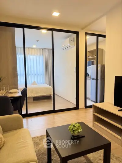 Modern apartment interior with open living room and bedroom, featuring sleek glass partitions and stylish decor.