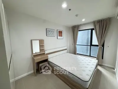 Modern bedroom with large window and minimalist furniture in a cozy apartment.