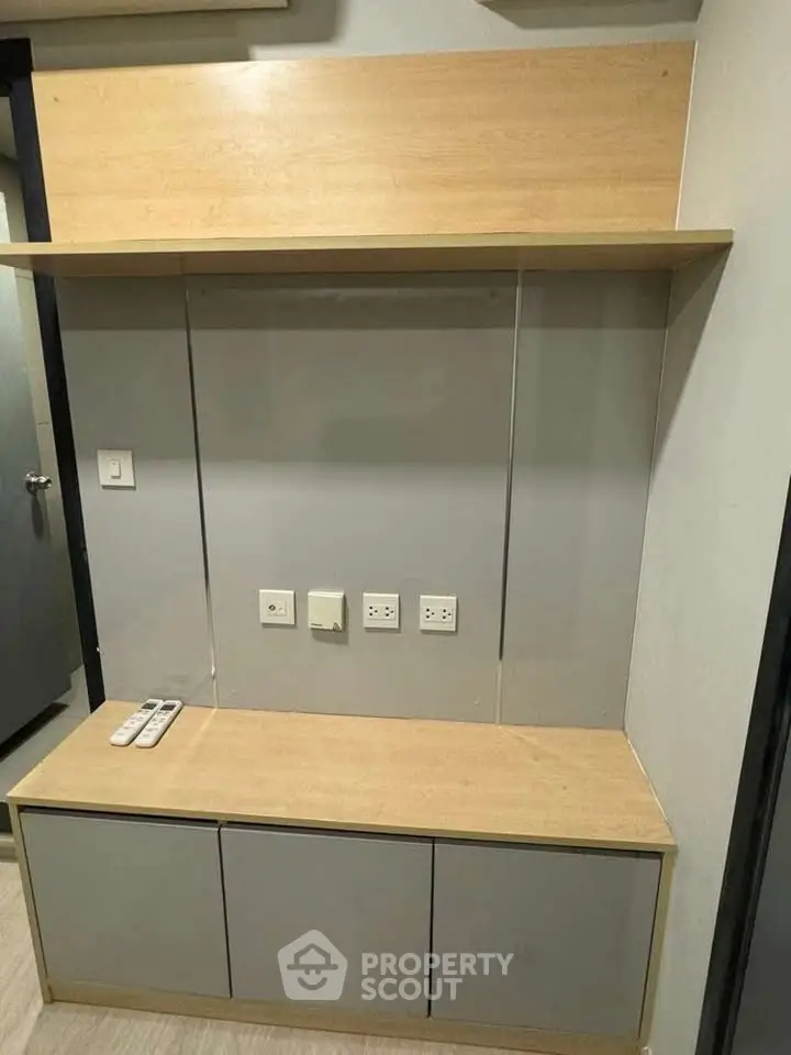 Modern minimalist entertainment unit with built-in shelves and power outlets, perfect for sleek living room design.