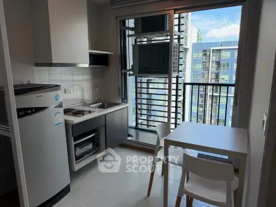 Modern compact kitchen with balcony view in urban apartment