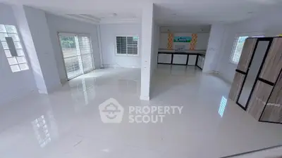 Spacious open-plan living area with modern kitchen and large windows