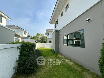 Modern suburban house with spacious backyard and lush greenery