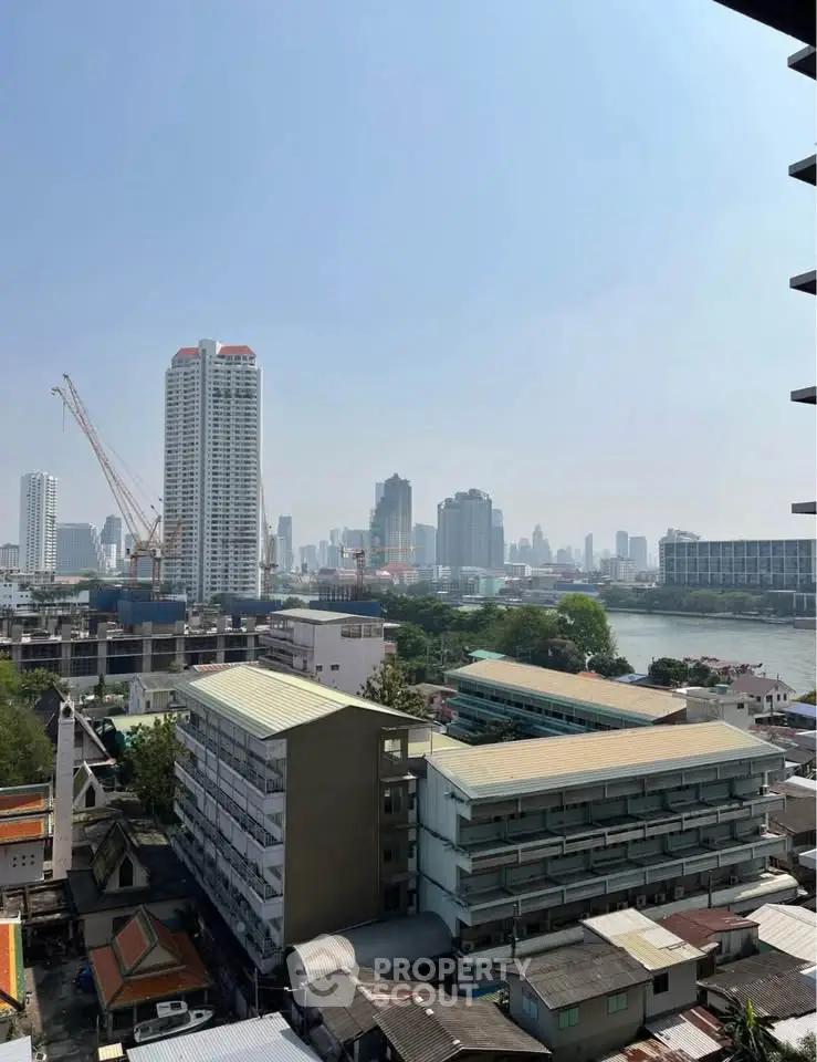 Stunning cityscape view from high-rise building with river and skyline in the background.