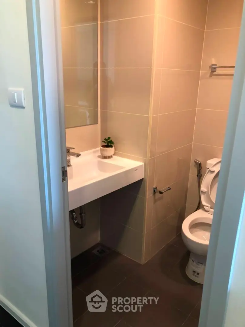 Modern bathroom with sleek fixtures and neutral tiles, perfect for a contemporary home.
