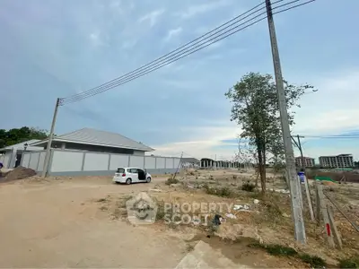 Expansive land plot with potential for development, featuring a single building and open surroundings.