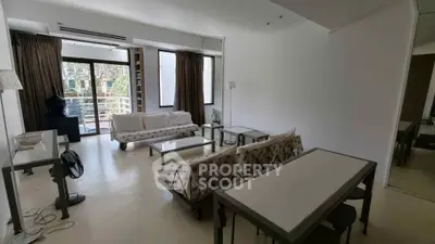 Spacious living room with modern furniture and large windows leading to a balcony.