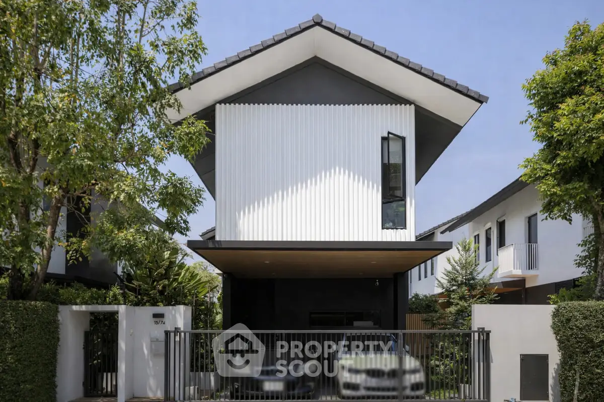 Modern two-story house with sleek design and spacious driveway in a serene neighborhood.