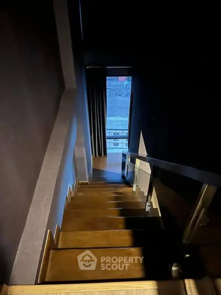 Modern staircase with sleek design and city view from the top landing.