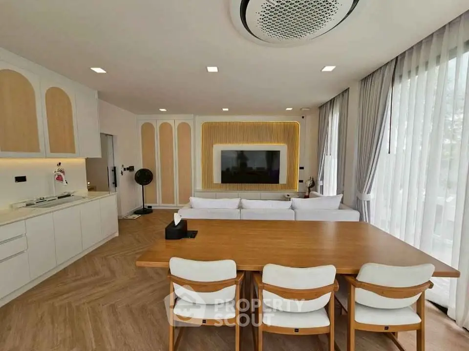 Modern open-plan living room with stylish dining area and sleek kitchen design.