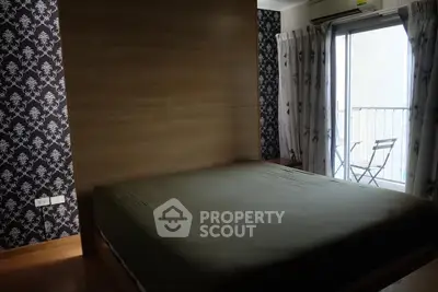 Cozy bedroom with balcony access and stylish wallpaper, perfect for relaxation and comfort.