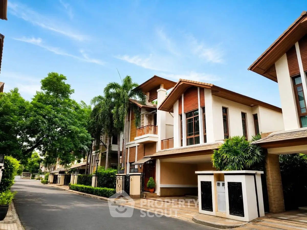 Luxurious modern villa with lush greenery and spacious driveway in a serene neighborhood.