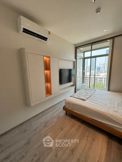 Modern bedroom with city view, featuring sleek design and air conditioning, perfect for urban living.
