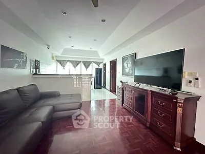 Spacious living room with elegant wooden flooring and modern furnishings in a stylish apartment.