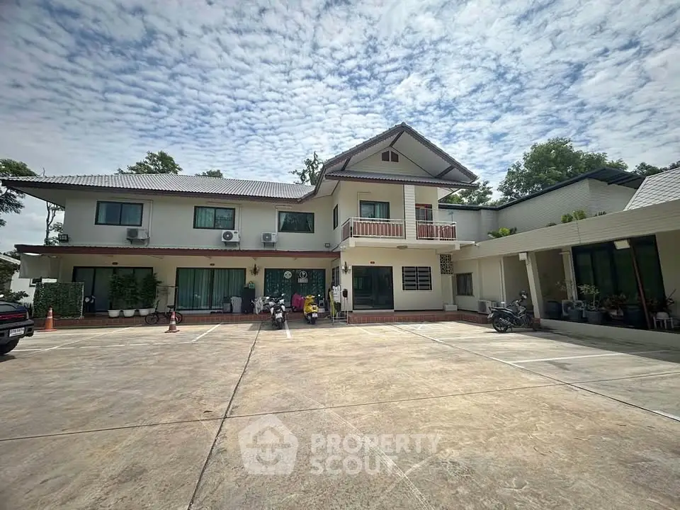 Spacious two-story house with ample parking and lush greenery, perfect for family living.