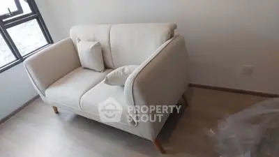 Cozy modern living room with stylish beige sofa and natural light.