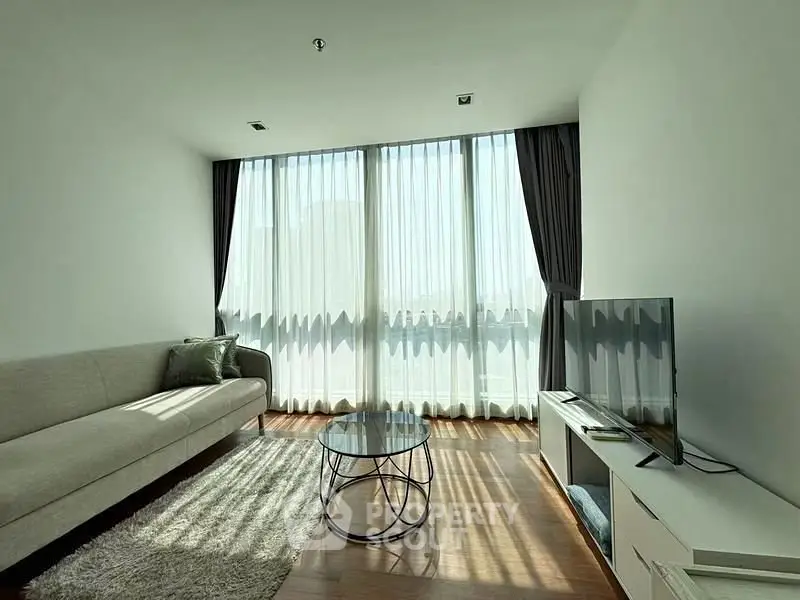 Spacious modern living room with large windows and stylish furniture