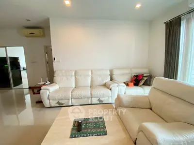 Spacious living room with white leather sofas and modern decor