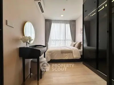 Modern bedroom with stylish decor and large window offering natural light.