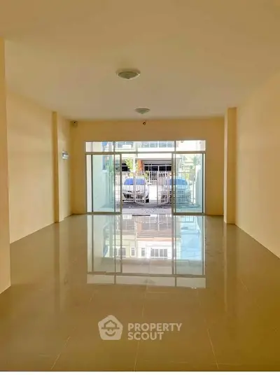 Spacious empty room with large windows and glossy tiled floor, perfect for customization.