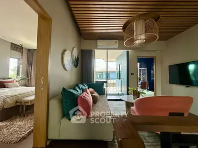 Modern living room with stylish decor and view into cozy bedroom