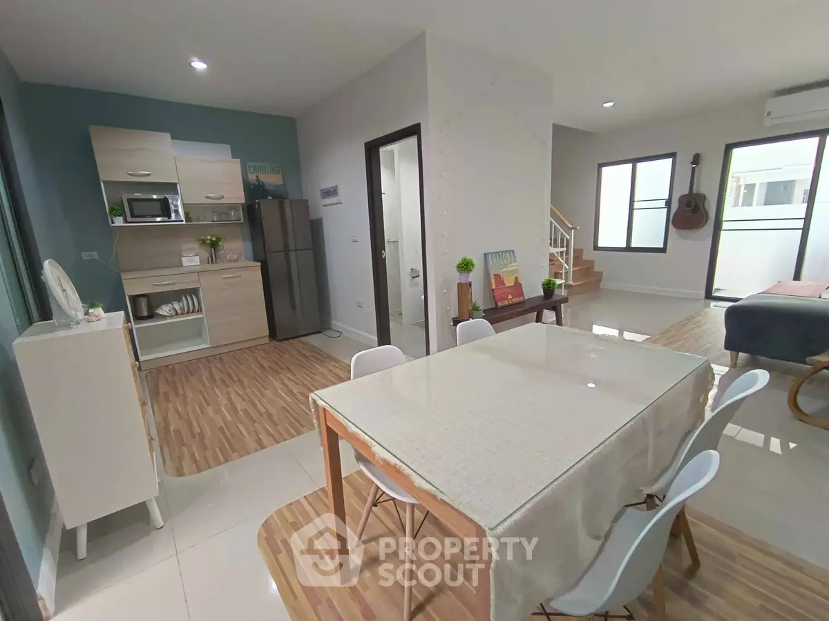 Modern open-plan living and dining area with stylish kitchen and natural light.