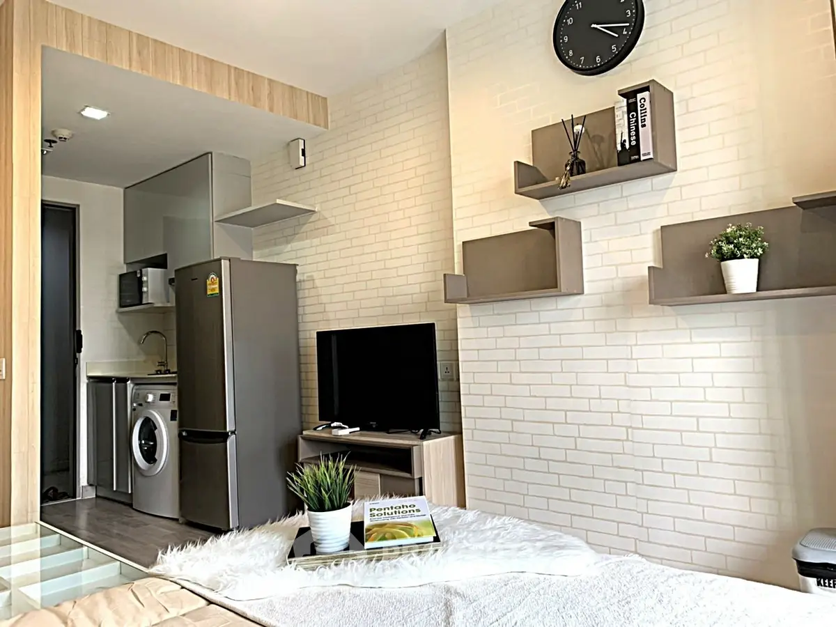 Modern studio apartment with stylish decor and compact kitchen area.