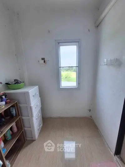 Cozy storage room with window view and organized shelving in a minimalist design.