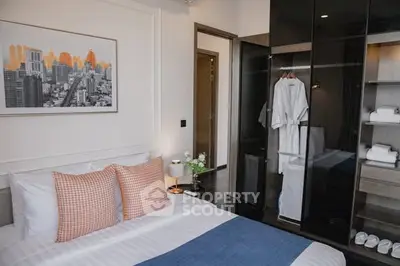 Modern bedroom with stylish decor and glass wardrobe in urban apartment.