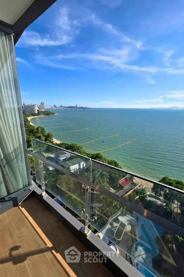 Stunning ocean view from a high-rise balcony with clear blue skies and city skyline.