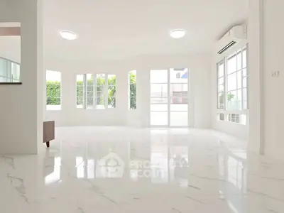 Spacious bright living room with marble flooring and large windows, perfect for natural light.