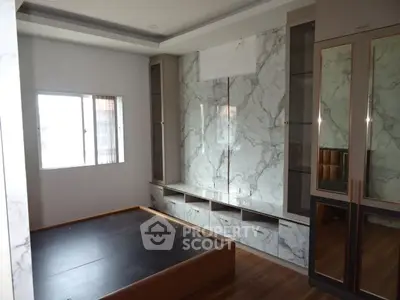 Spacious bedroom with elegant marble accents and ample storage space