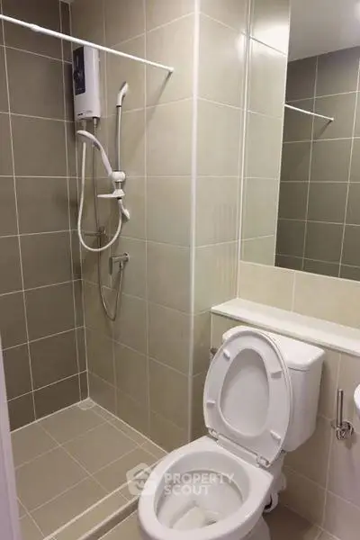 Modern bathroom with shower and toilet in sleek tiled design