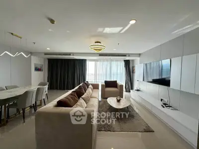 Spacious modern living room with elegant decor and large windows offering natural light.