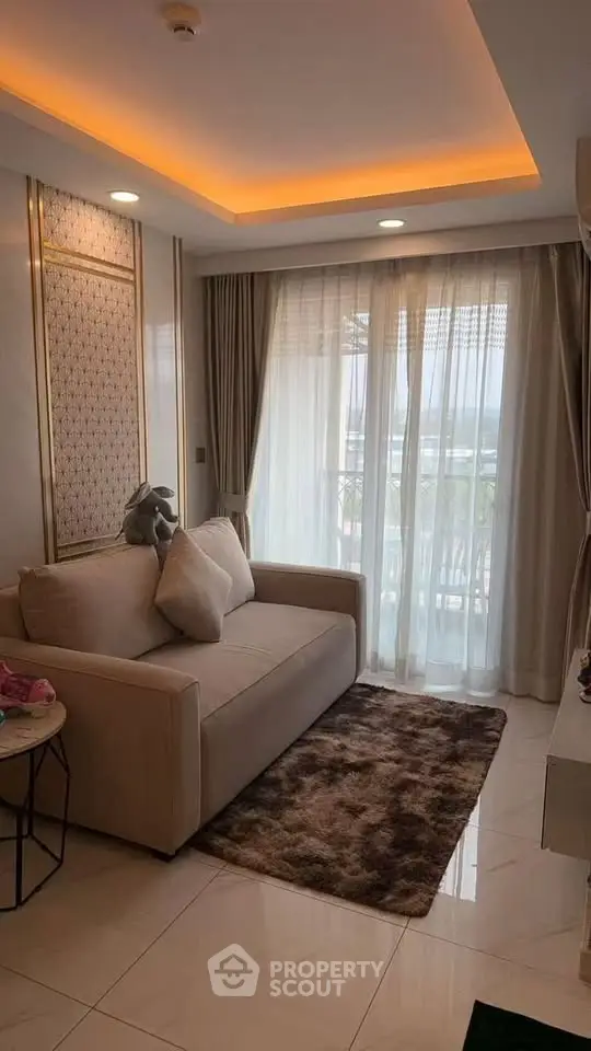 Cozy living room with elegant lighting and plush sofa near a large window with curtains.