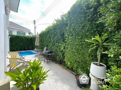 Charming garden patio with lush greenery and small pool, perfect for relaxation and outdoor enjoyment.