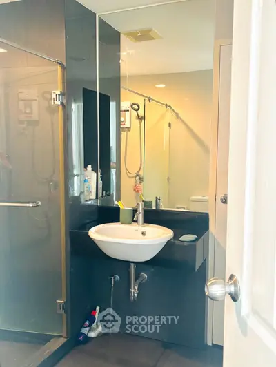 Modern bathroom with sleek sink and glass shower enclosure